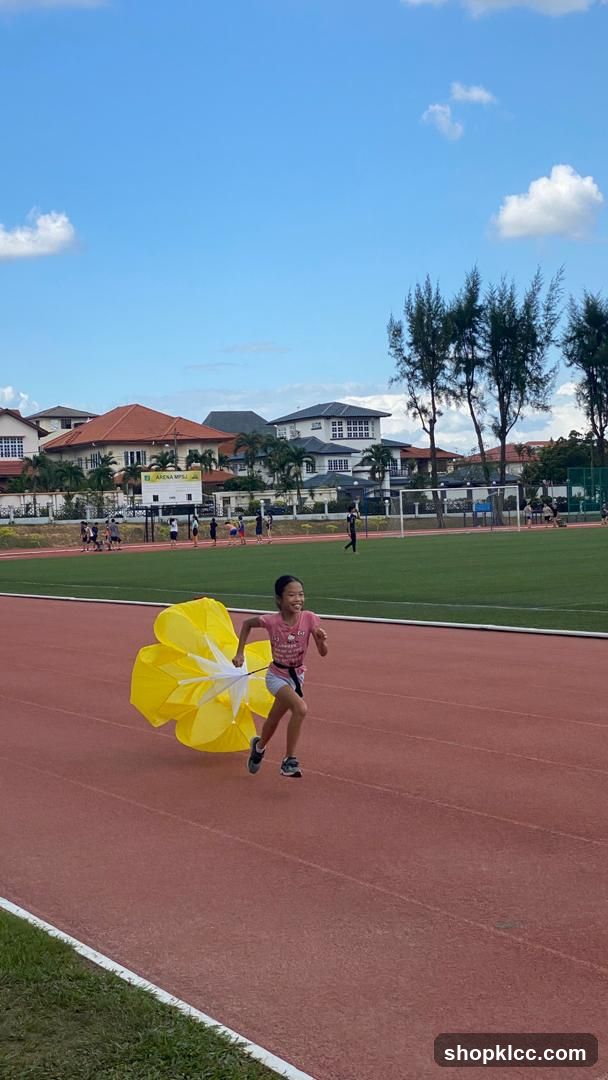 Child Running with Yellow Umbrella on Track