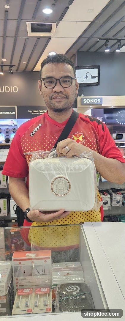 Man holding a white portable speaker