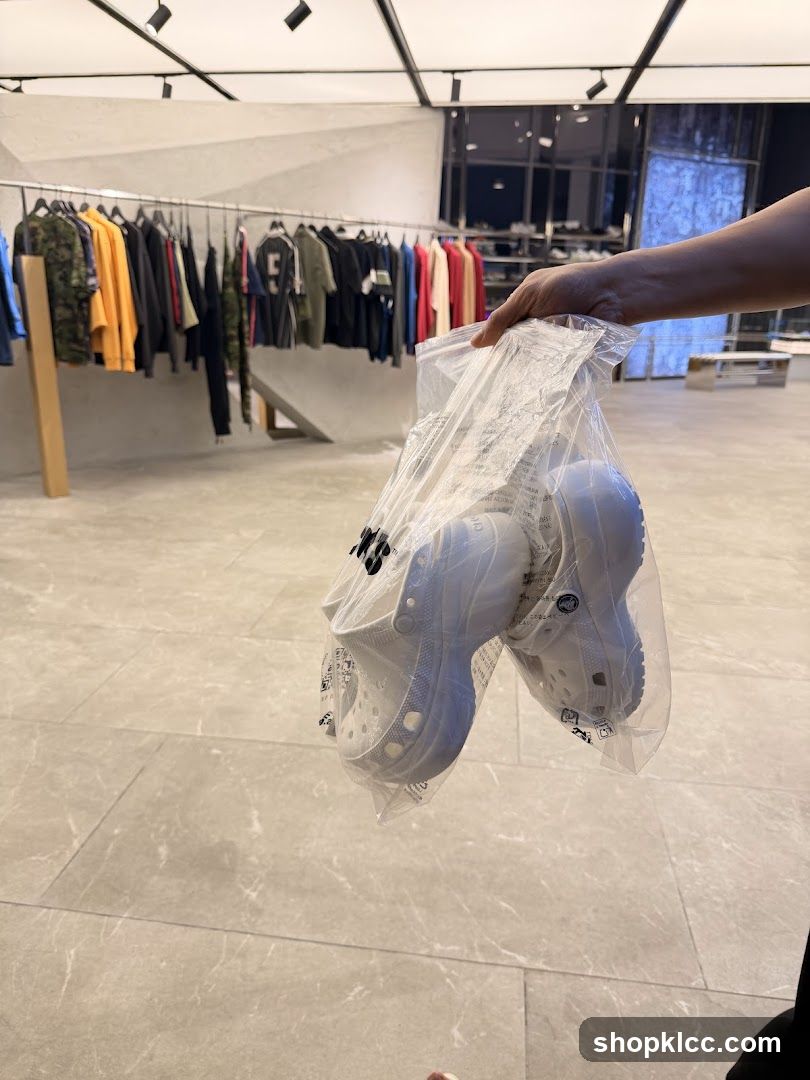 Person holding a bag of white Crocs