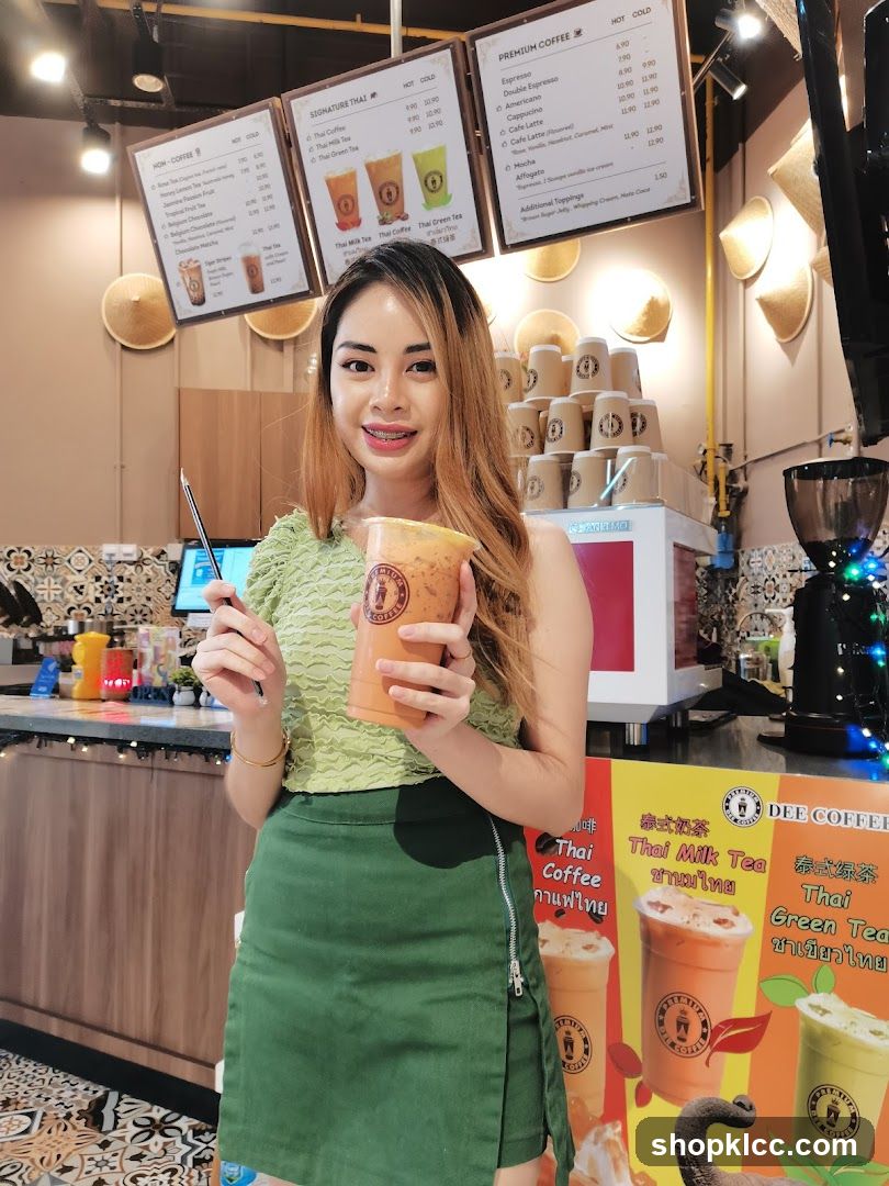 Woman holding Thai milk tea at Dee Coffee shop