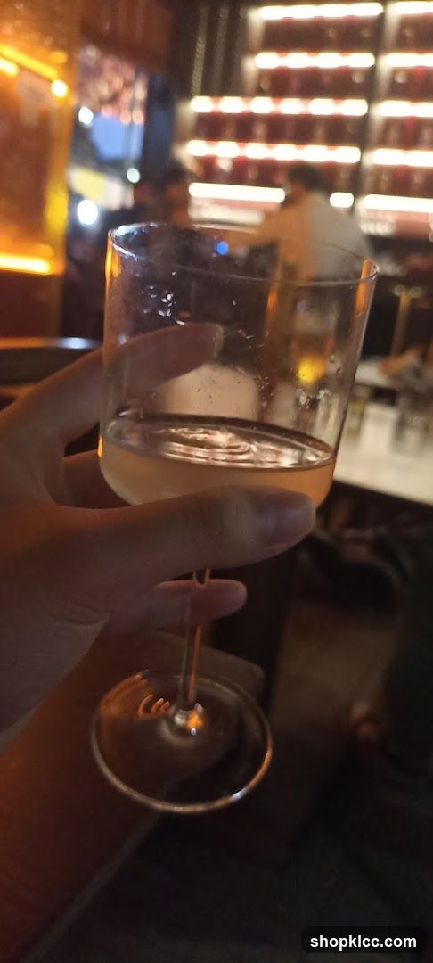 A hand holding a glass of wine