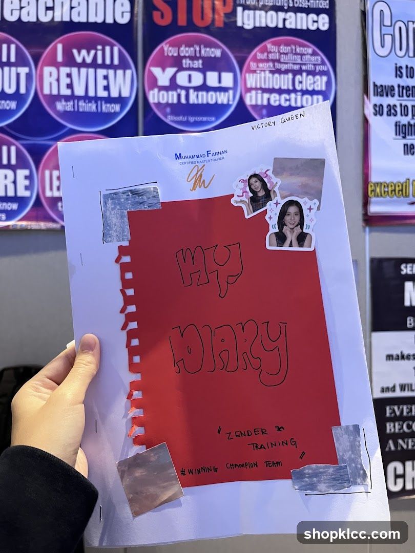 Hand holding a diary with motivational posters in the background