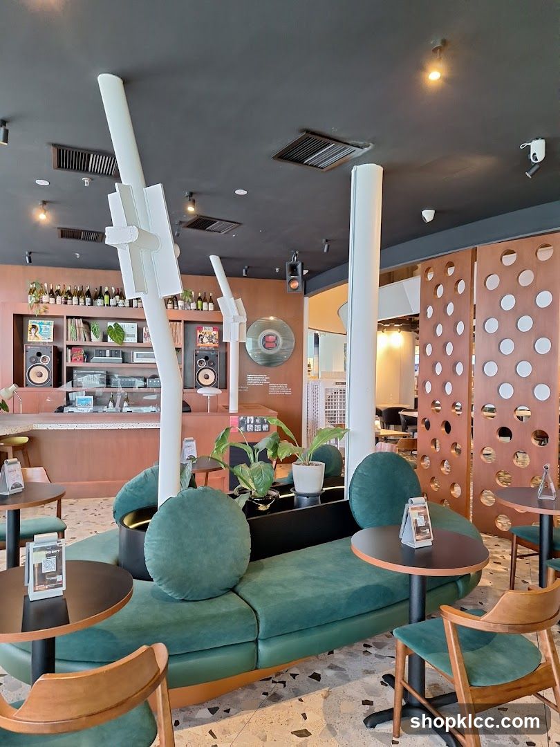 Modern cafe interior with green seating and vinyl records