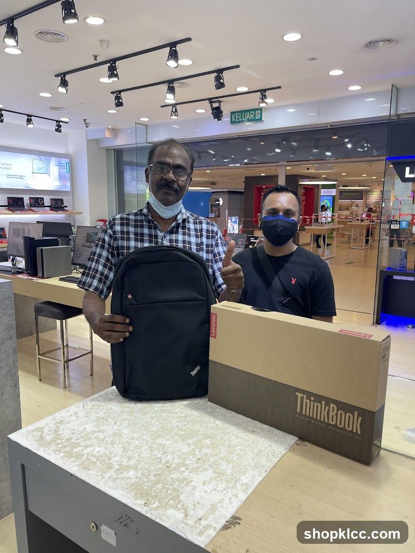 Two men with a laptop and backpack
