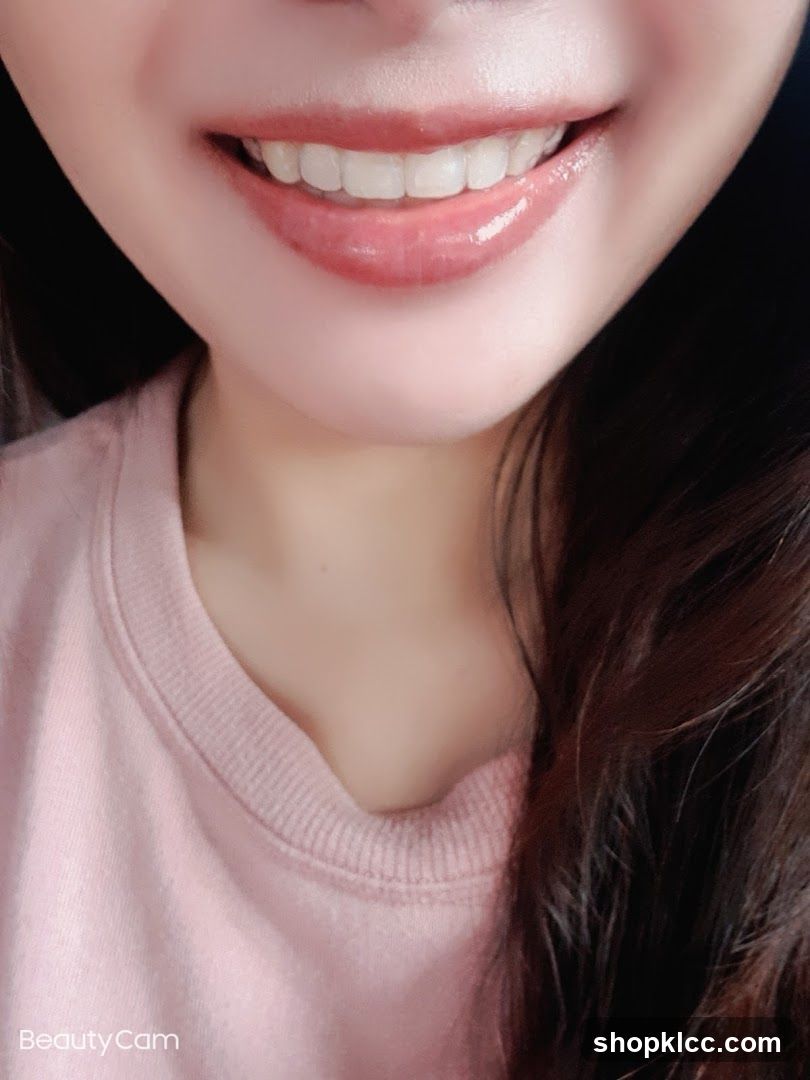 Close-up of a smiling mouth with glossy lips