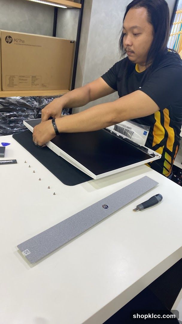 Technician assembling a computer monitor
