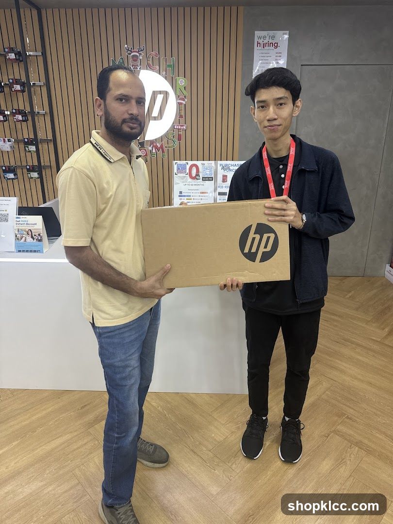 Two men holding a laptop box