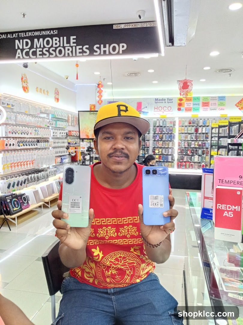 Man holding phones in a mobile accessories shop