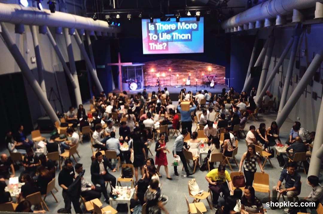 People gathered in a large hall with a stage