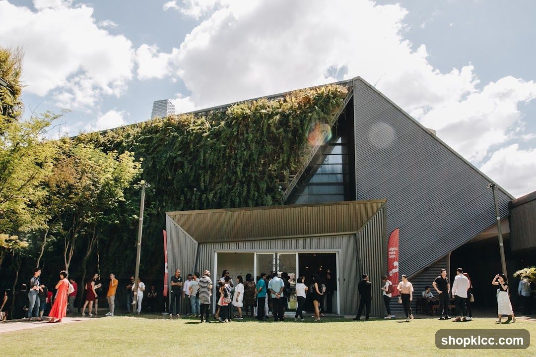 People gathered outside a modern building with a living wall