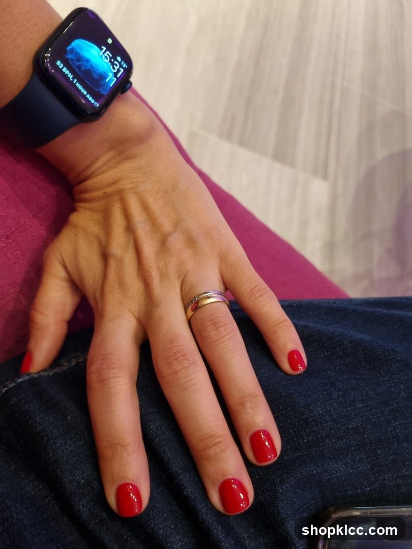 Woman's hand with red nail polish and smartwatch
