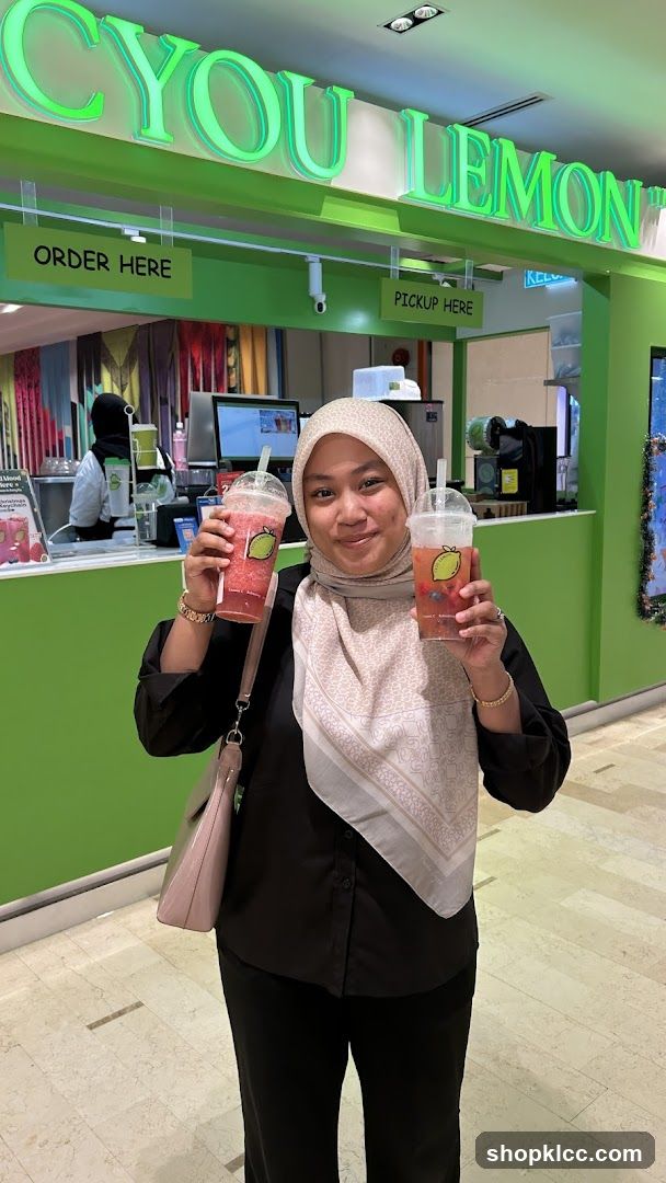 Woman holding drinks at a beverage counter