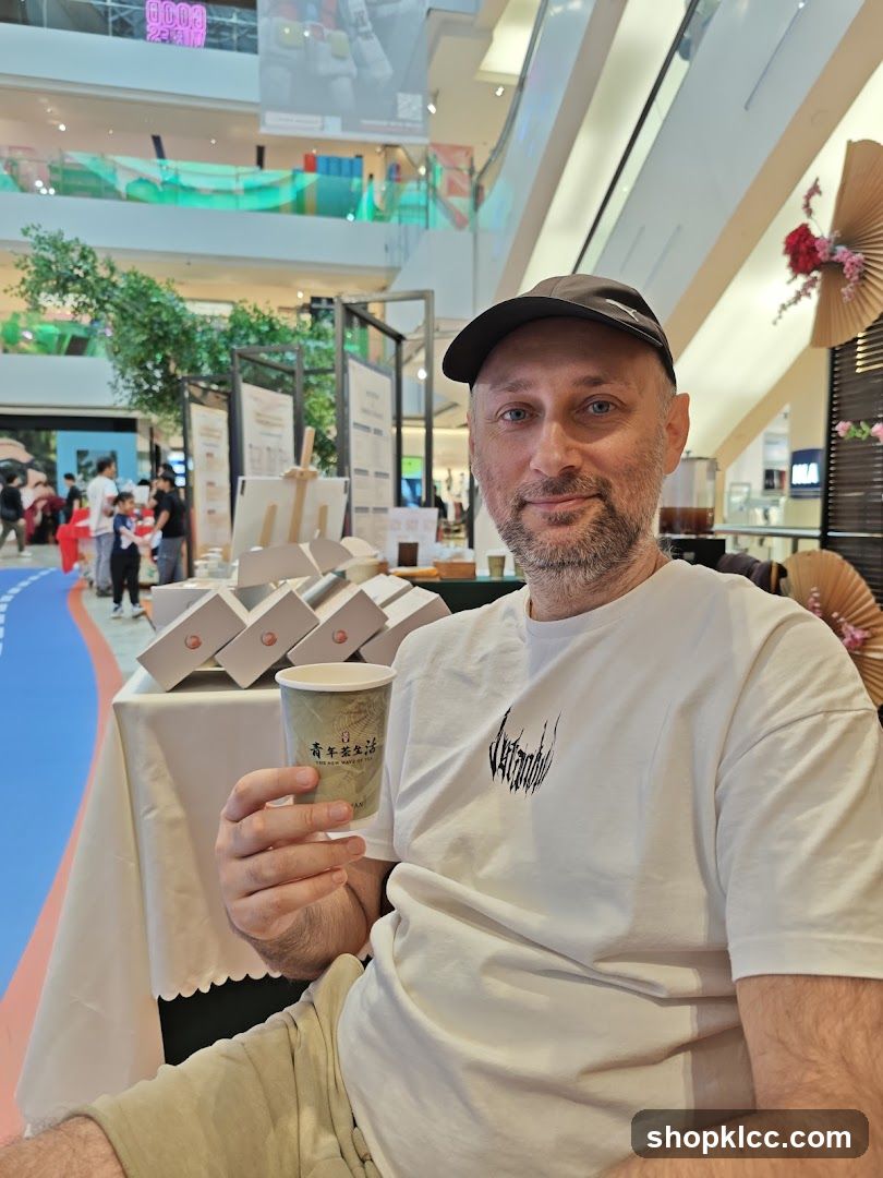 Man holding a cup in a mall