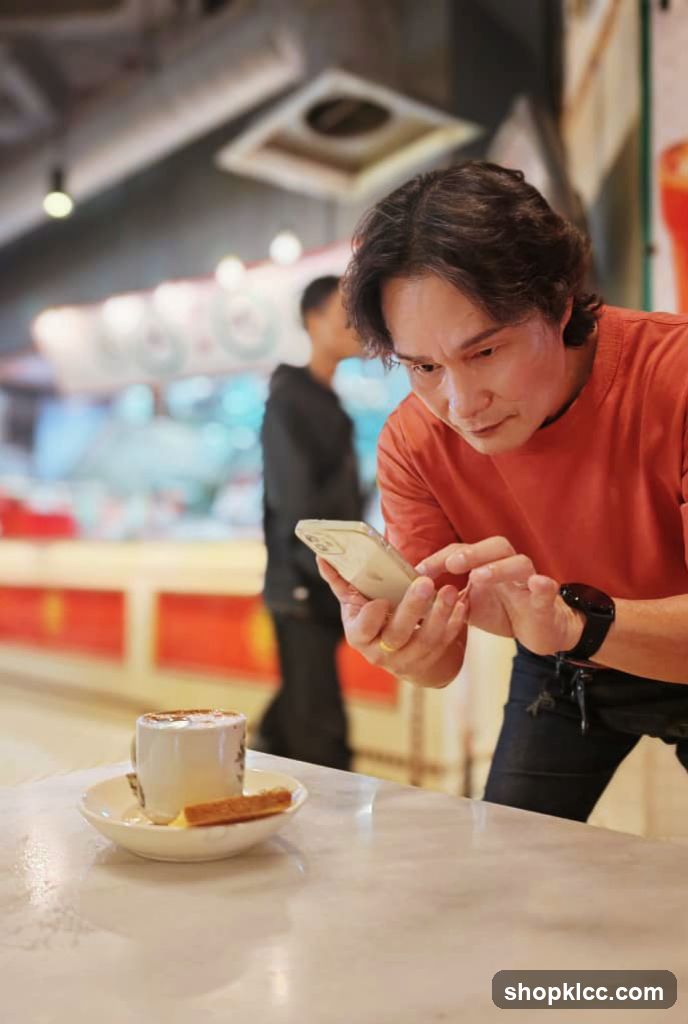 Man Checking Phone at Cafe Table