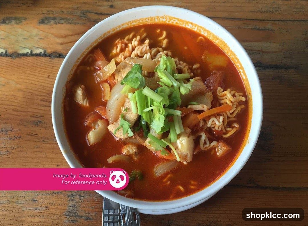 Bowl of spicy noodle soup with vegetables and greens