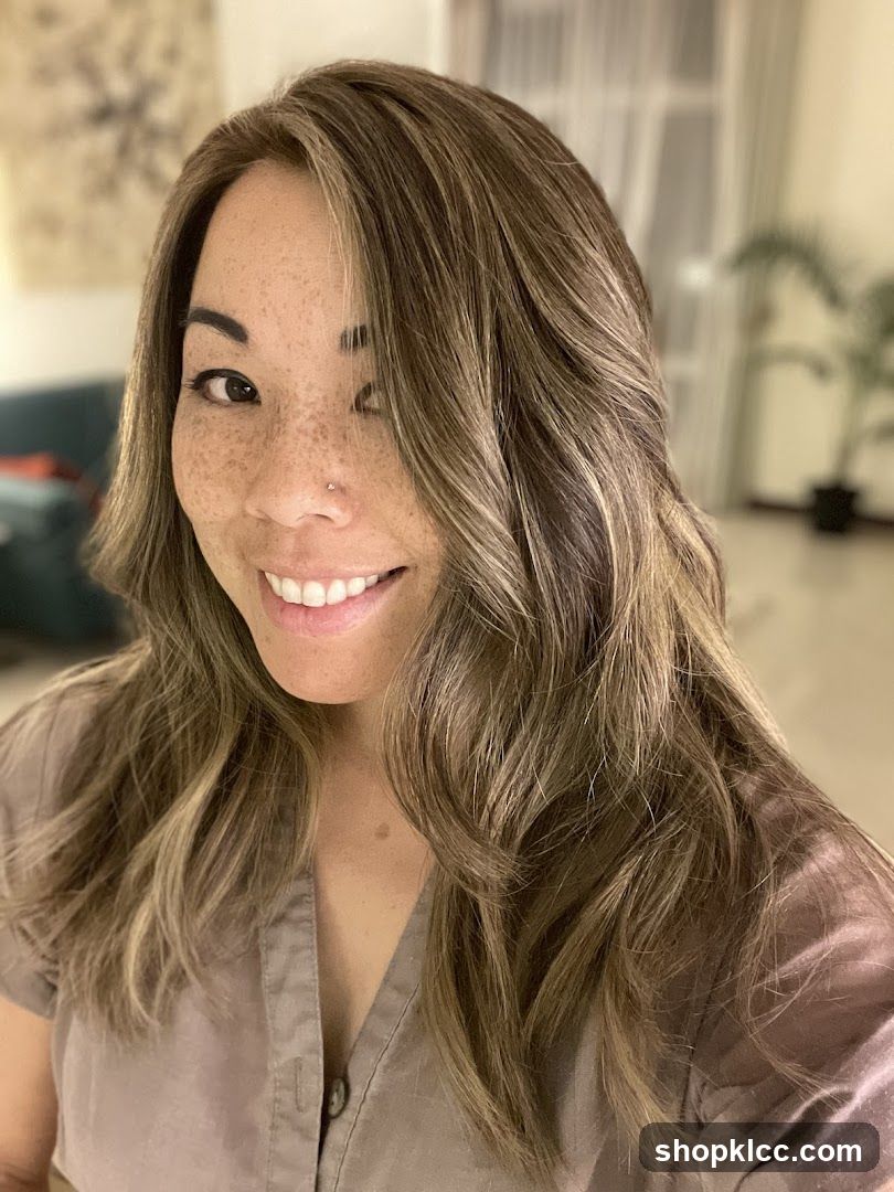 Woman with wavy hair and freckles smiling at camera