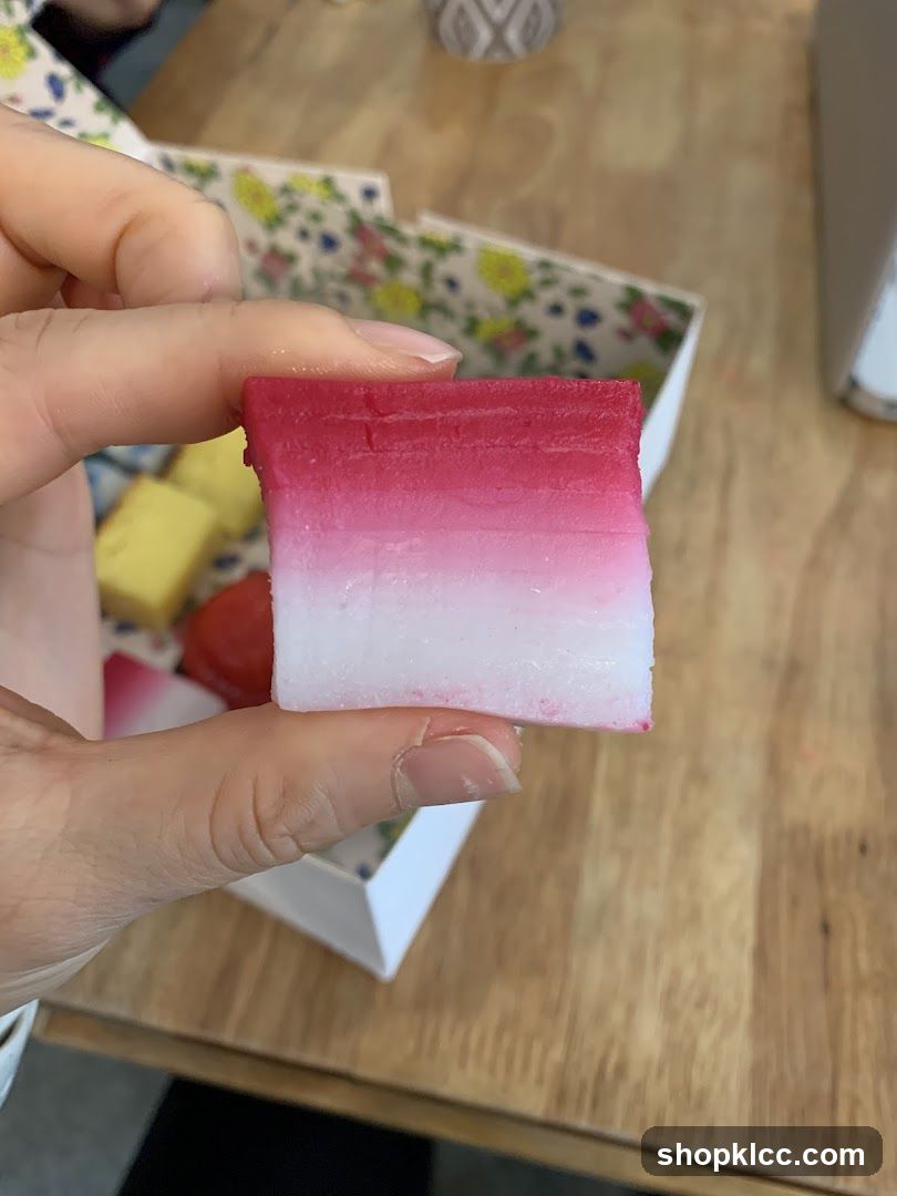 Hand holding pink and white layered soap