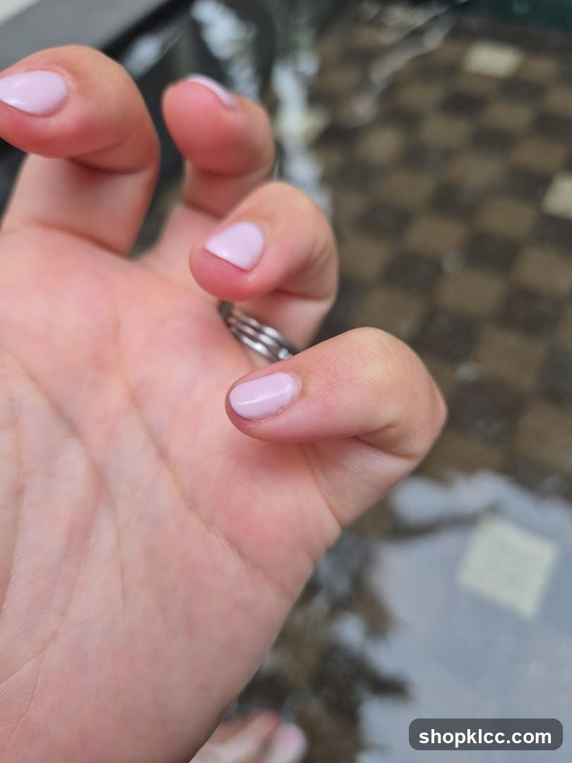 Hand with light pink nail polish