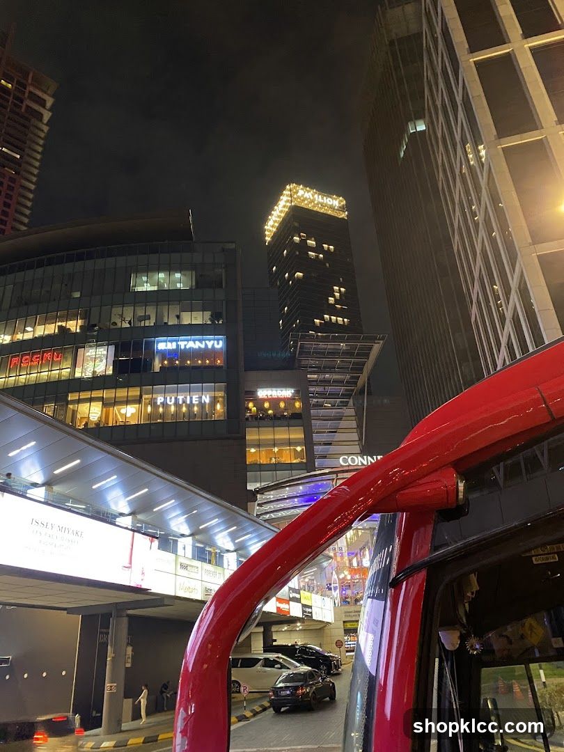 Nighttime cityscape with illuminated buildings and a red vehicle