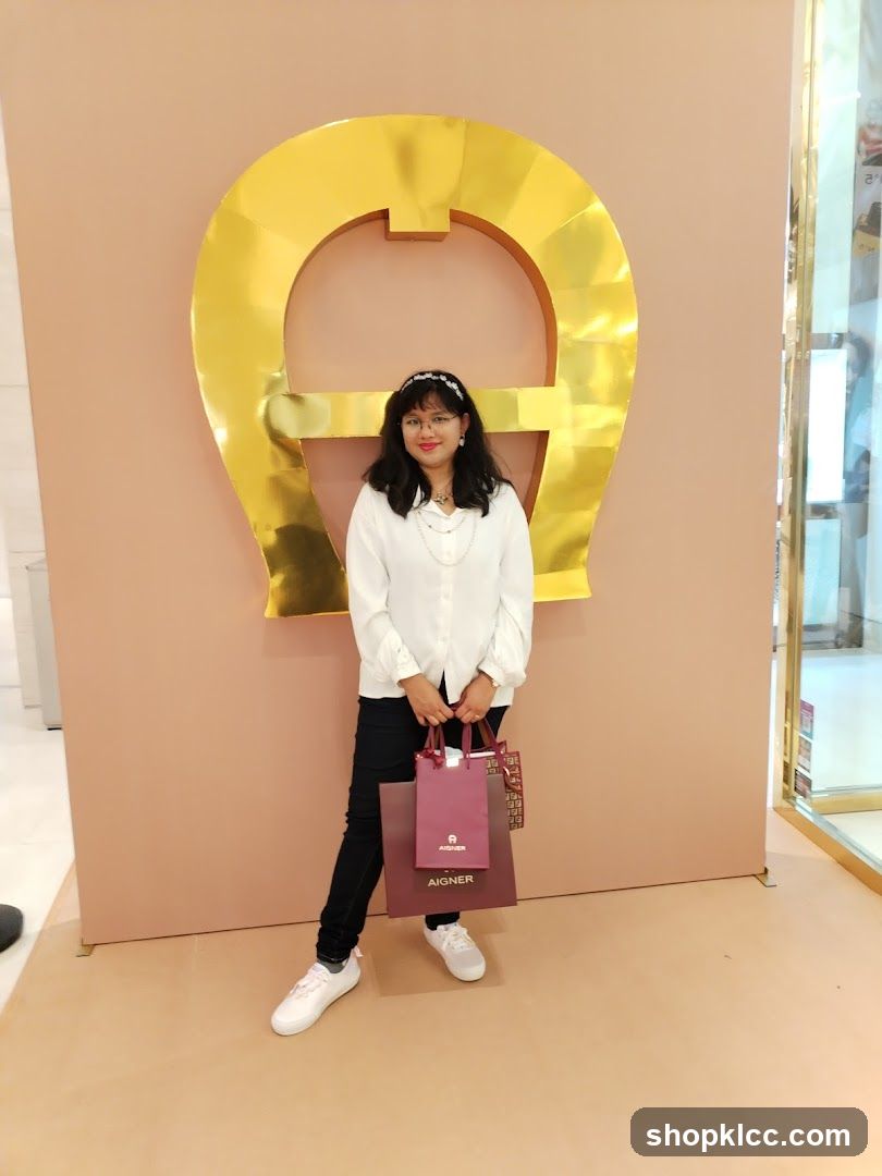 Woman Posing with Shopping Bags in Front of a Large Logo