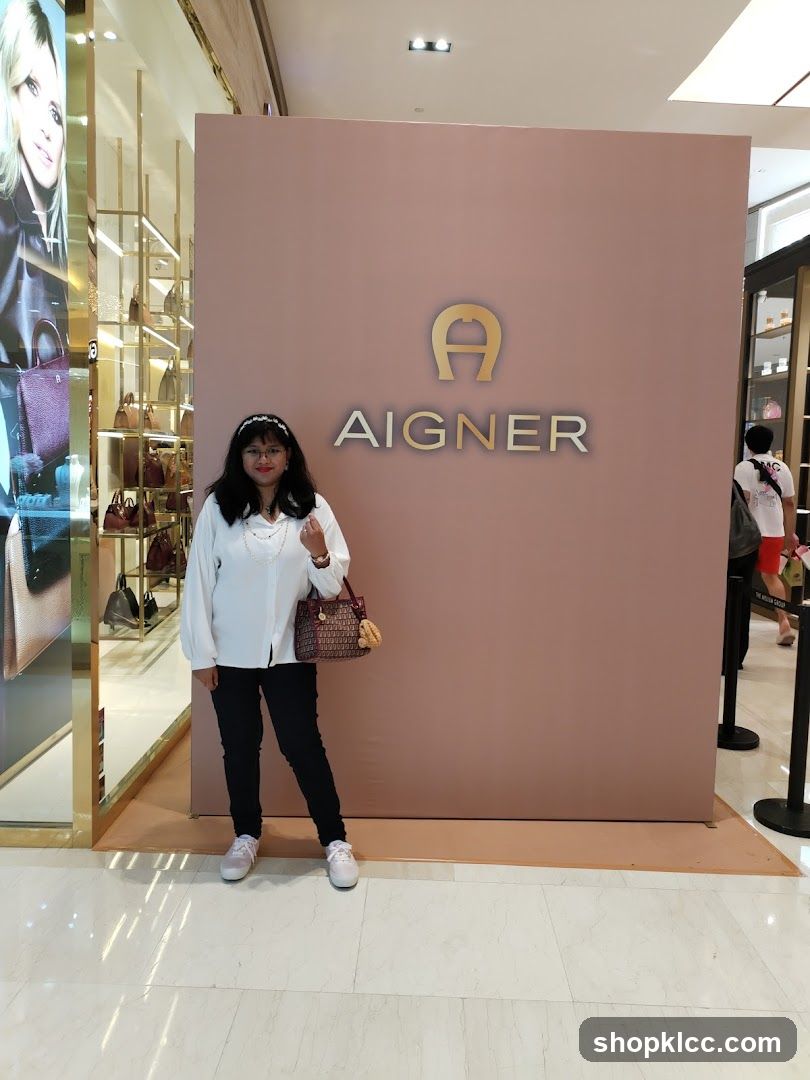 Woman Poses in Front of Aigner Logo