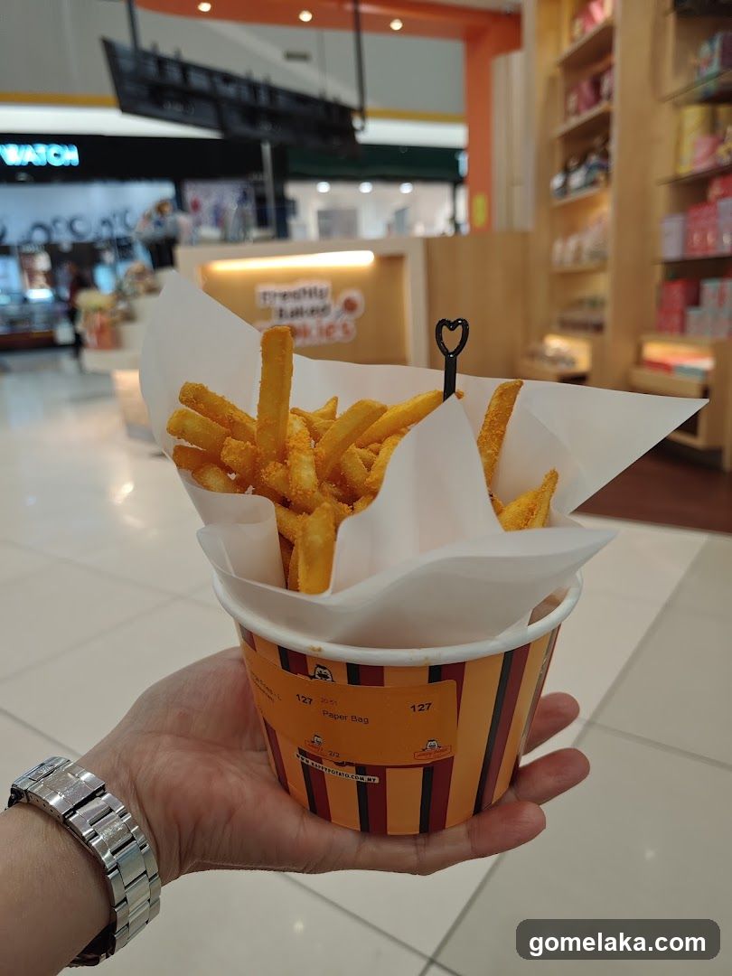 Hand holding fries in shopping mall