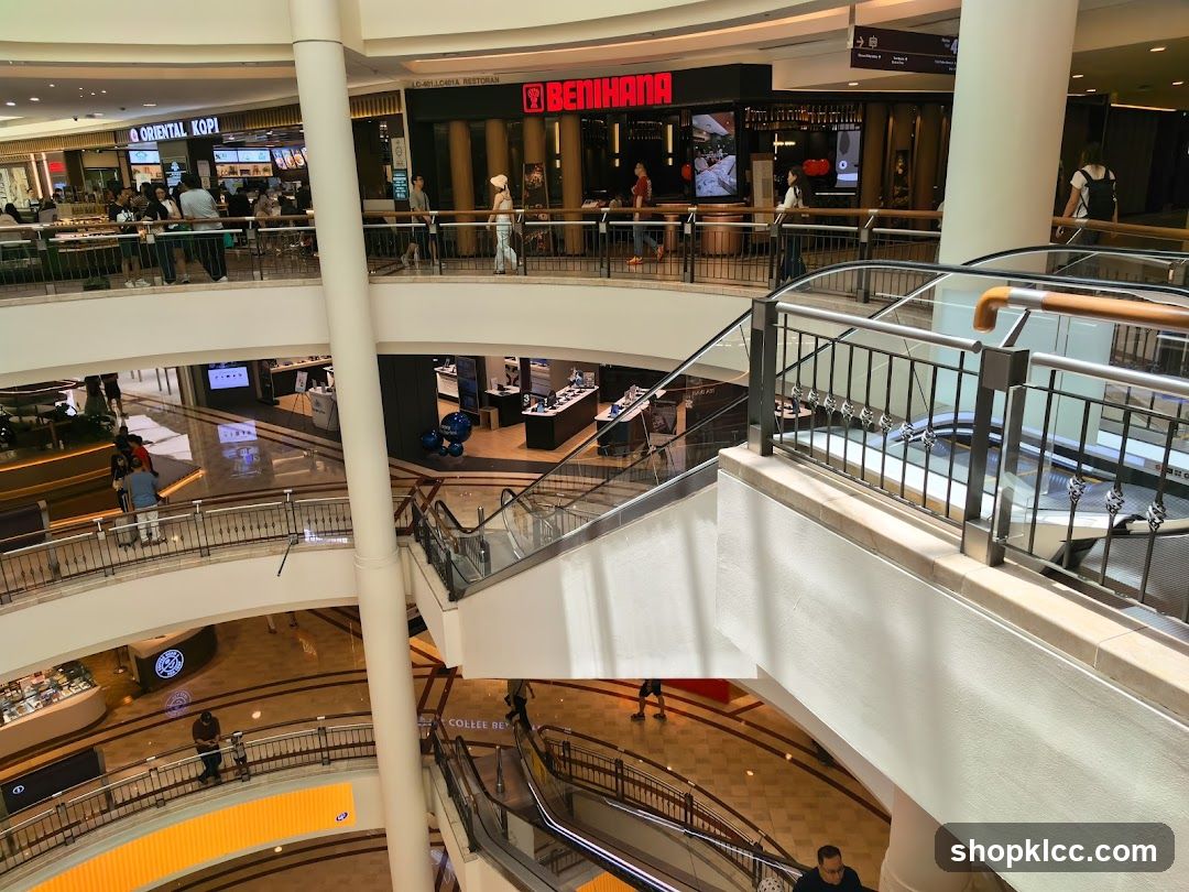 Multi-level shopping mall interior with escalators and various shops