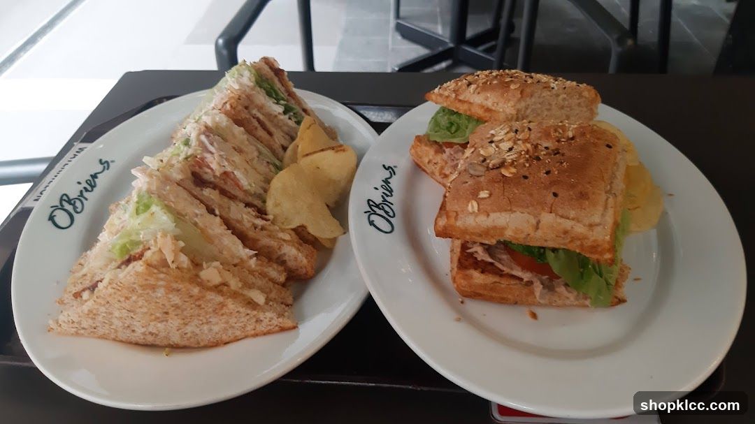 Two plates of sandwiches with potato chips