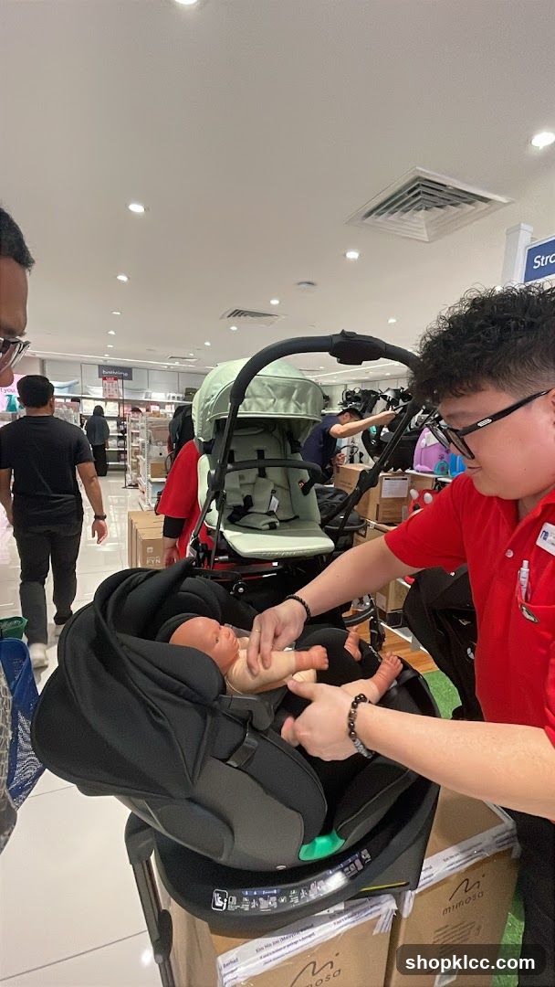 Staff demonstrating a car seat and stroller