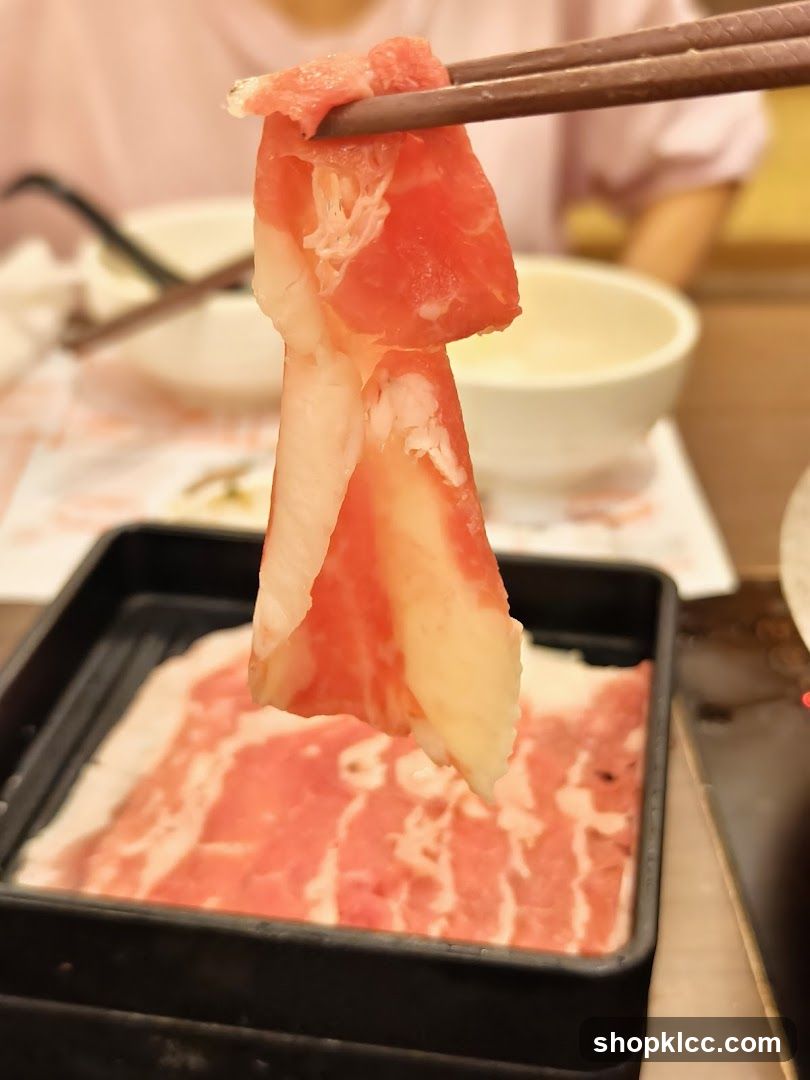 Sliced Meat Being Held with Chopsticks