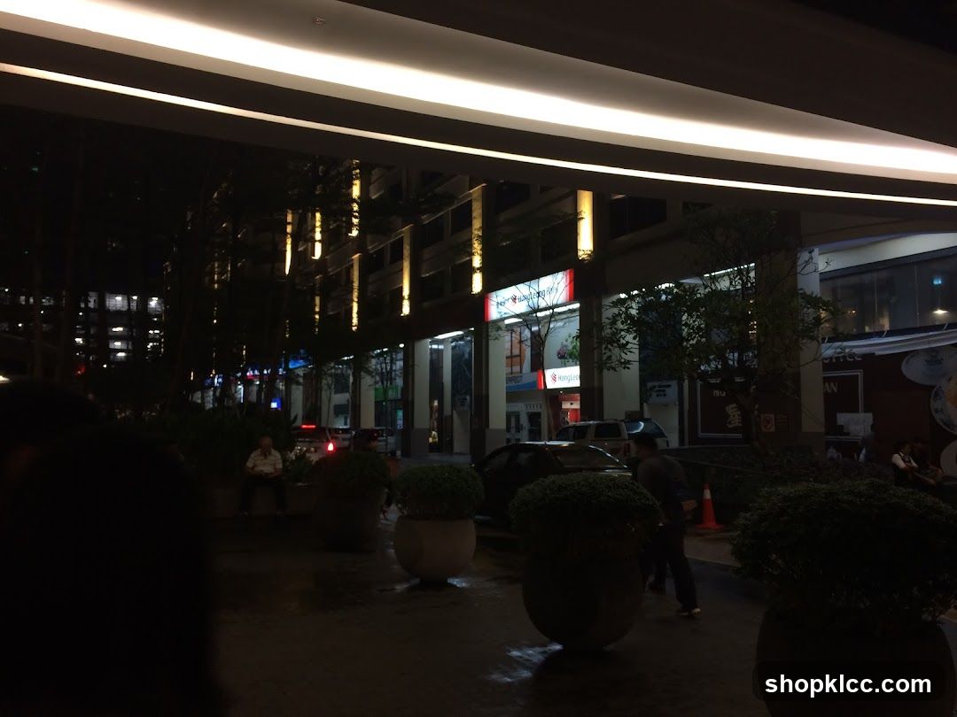 Nighttime street view with illuminated buildings and trees