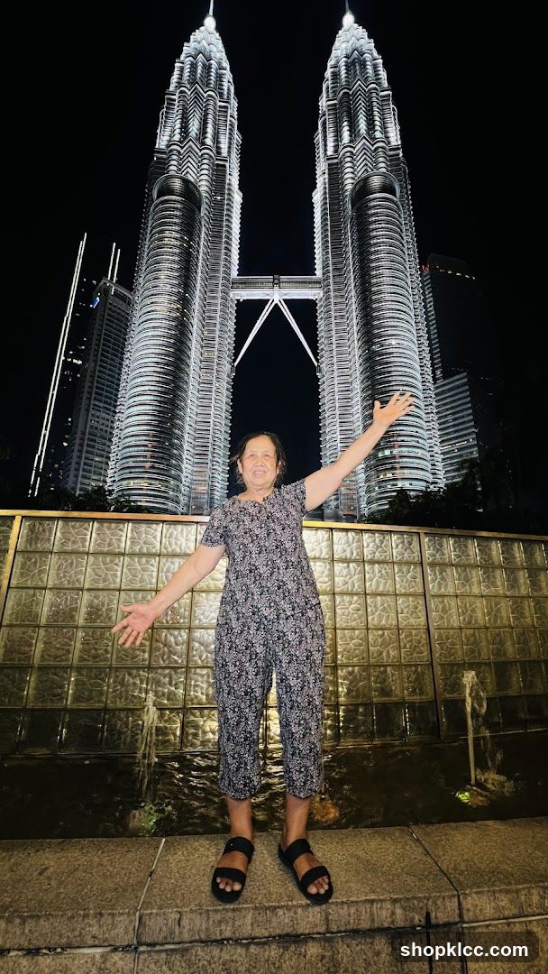 Woman Posing in Front of Petronas Towers at Night