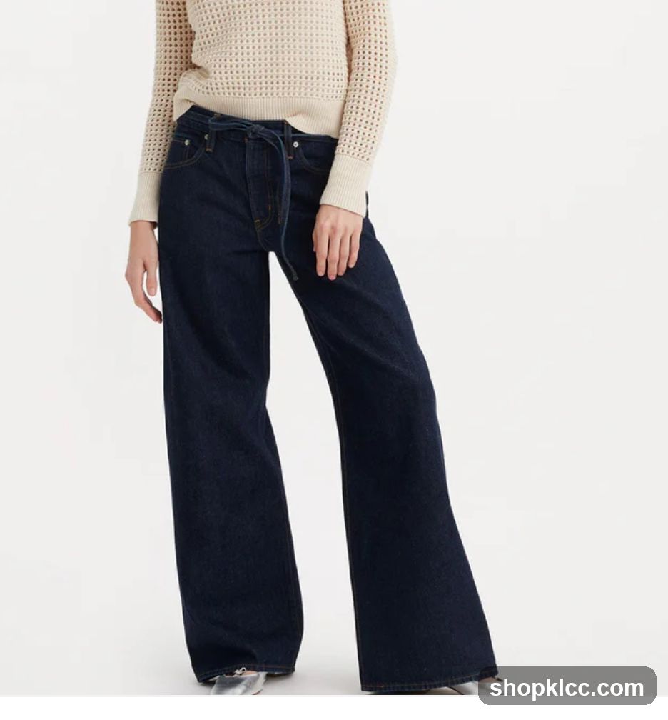 Woman wearing dark wash wide-leg jeans and a cream sweater