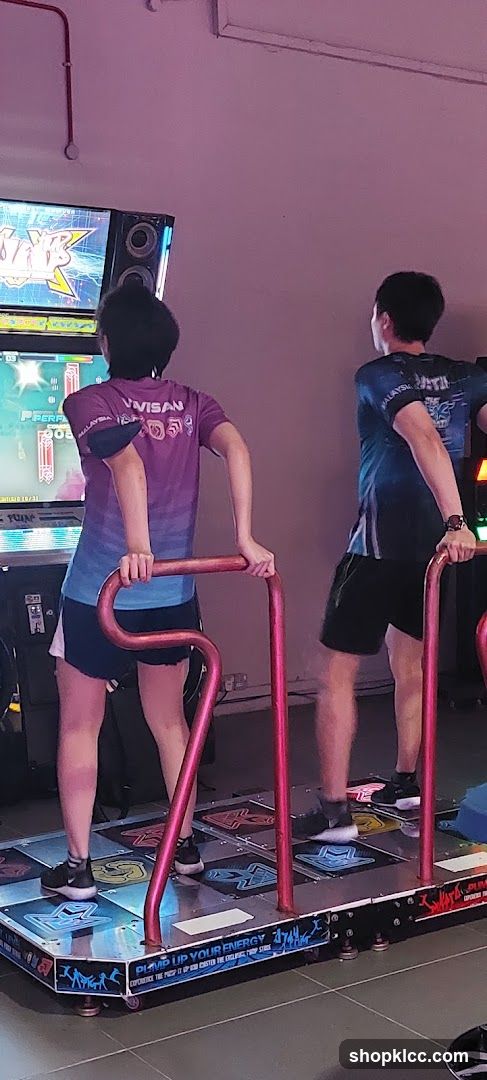 People playing a dance arcade game