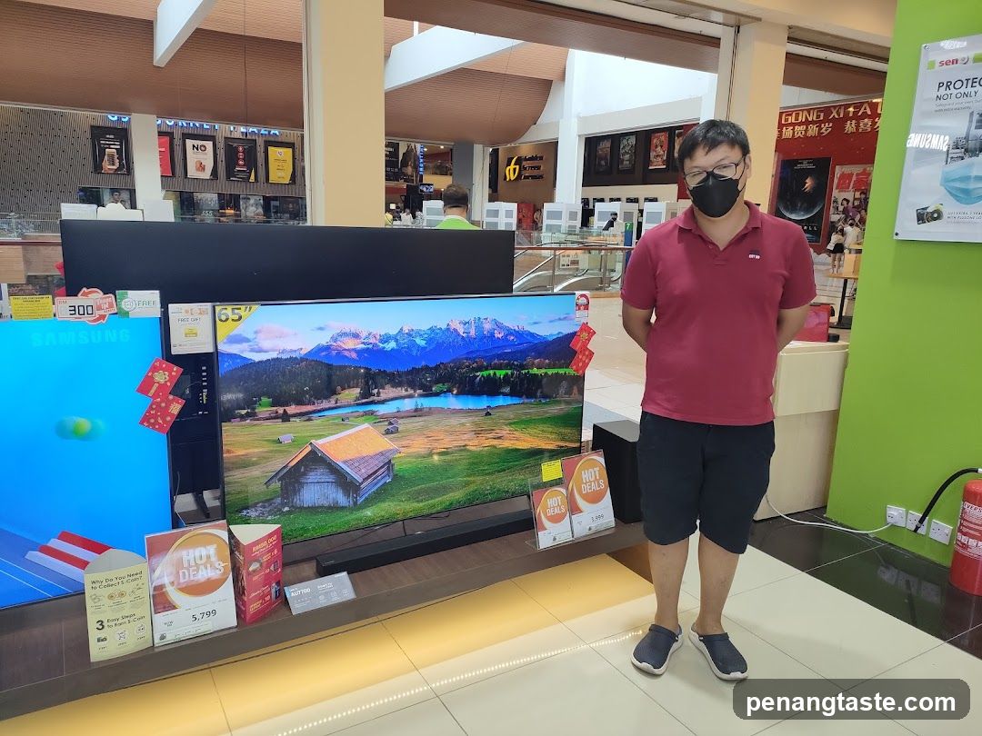 Man standing next to televisions