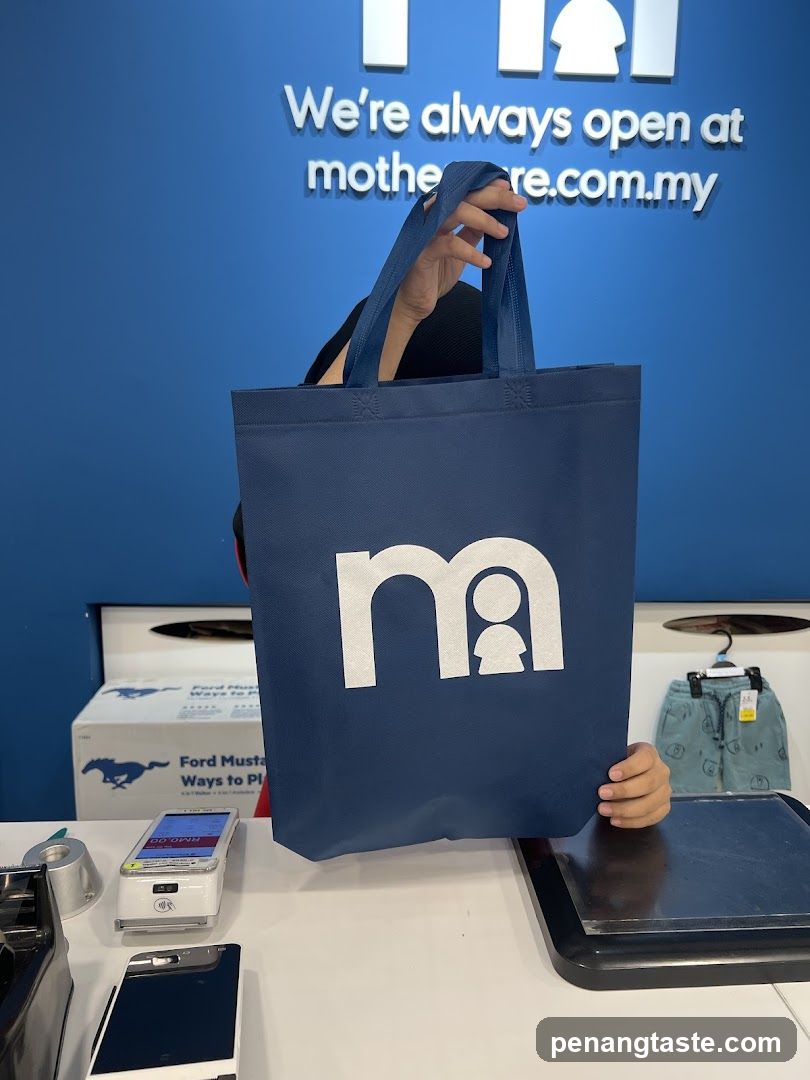 Person holding a branded tote bag