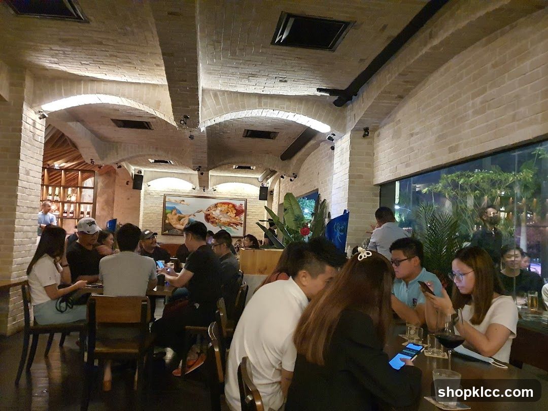 Interior of a bustling restaurant or bar with brick arches and patrons dining at tables.