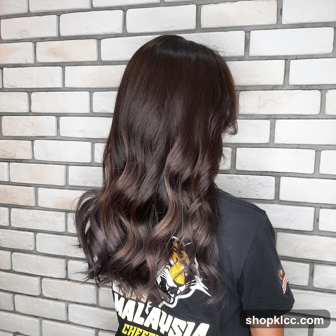 Person with long wavy hair against brick wall