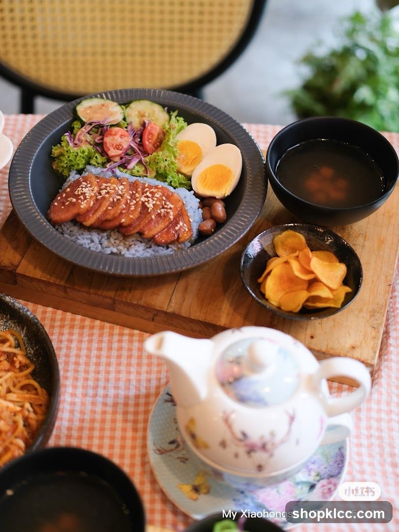 Bowl of food with rice, egg, and sides on a table