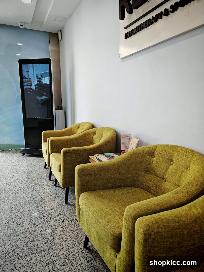 Lounge Area with Green Armchairs and Digital Screen