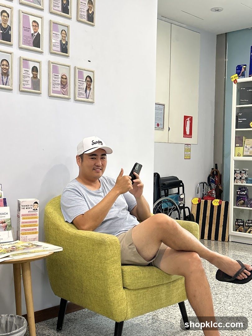 Man sitting in a green armchair holding phone