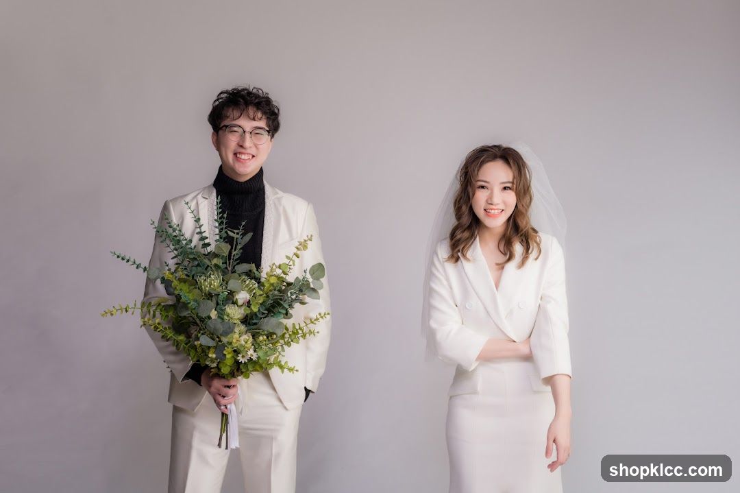 Couple in White Wedding Attire Holding Bouquet