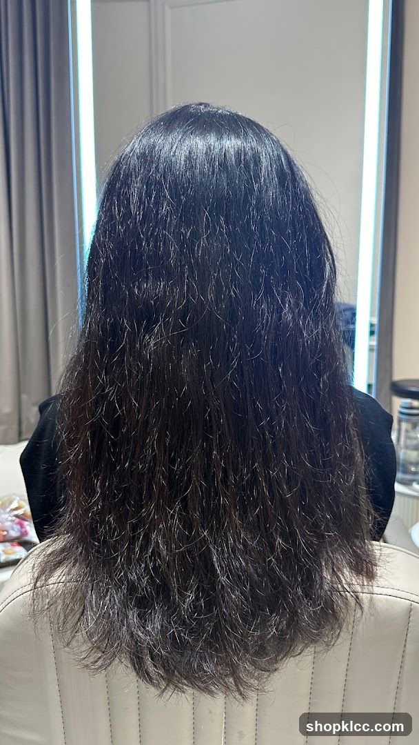 Back of a person with long dark hair in an indoor setting