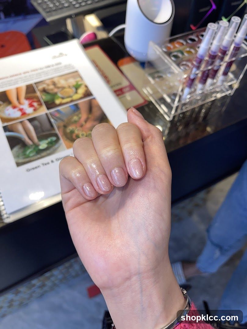 Hand with manicured nails and spa menu