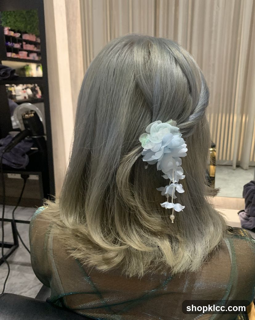 Woman with styled grey hair and a floral hair accessory