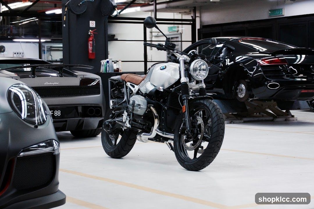 Motorcycle in a garage with luxury cars
