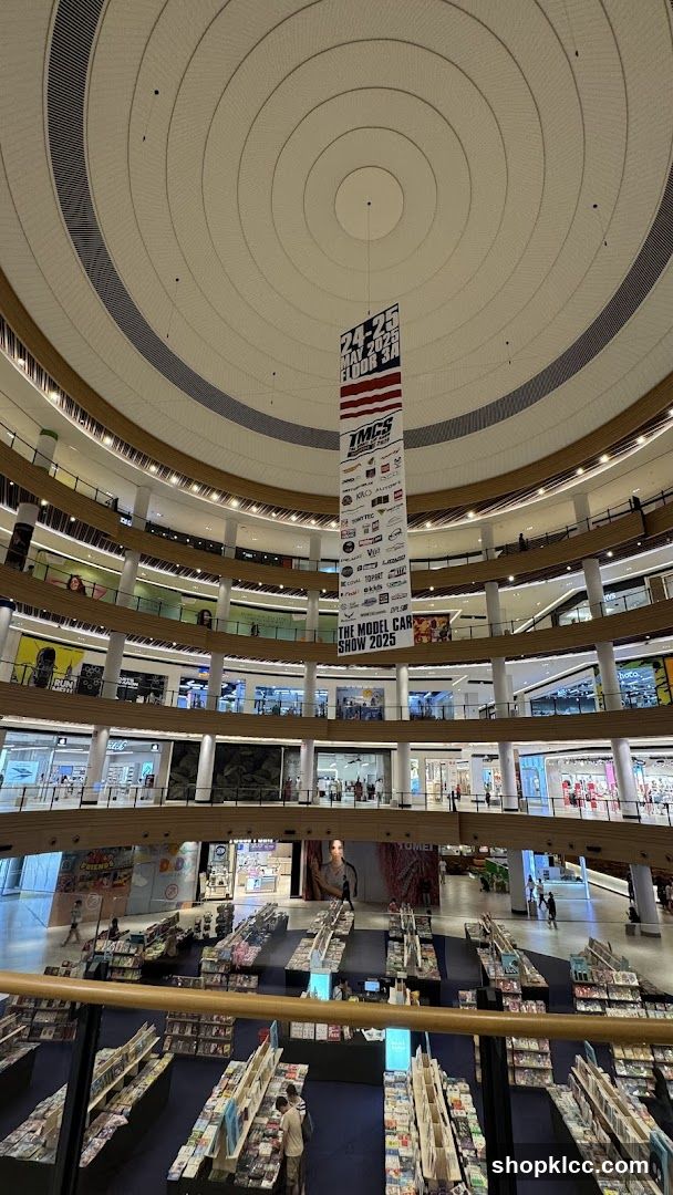 Interior of a multi-level shopping mall with a banner for a model car show