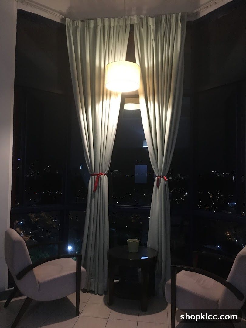 Chairs and table by window with city view at night