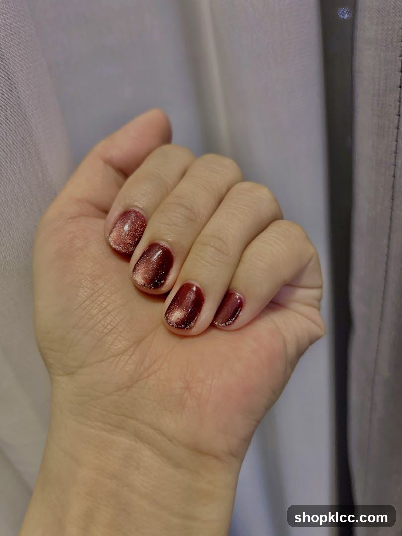 Hand with Burgundy Cat Eye Nails