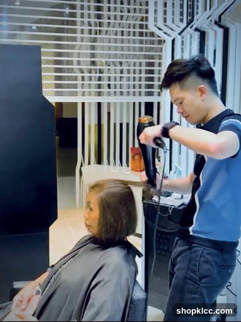 Hairdresser drying client's hair
